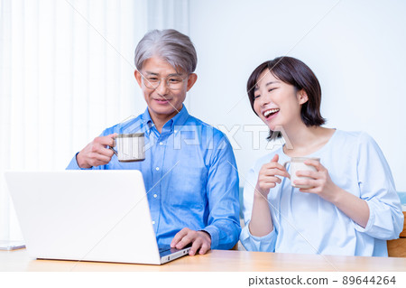 Adult parents and children using laptops in the living room 89644264