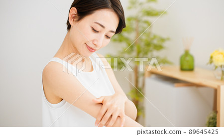 一個年輕女子按摩她的上臂的美麗形象 89645425