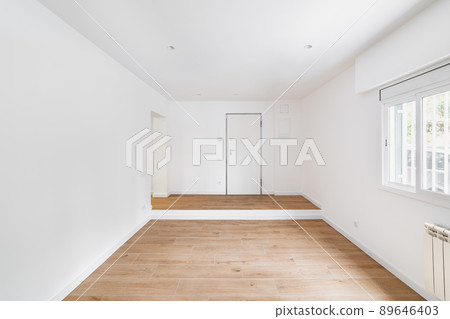 Empty room after renovation with window, white walls and wooden floor in new apartment Empty room after renovation with window, white walls and wooden floor in new apartment 89646403