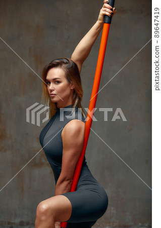 beautiful girl in sports uniform is training kung fu in the studio, fighter athlete, practicing martial arts with a stick beautiful girl in sports uniform is training kung fu in the studio, fighter athlete, practicing martial arts with a stick 89647419