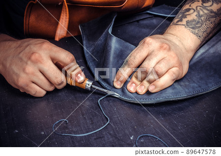 Currier of leather creates quality product of leather at his tanning shop Currier of leather creates quality product of leather at his tanning shop 89647578