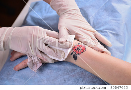 tattoo artist wipes tattoo 89647623