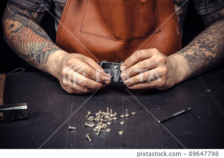 Leather Currier creating new leatherwork at his work area 89647798
