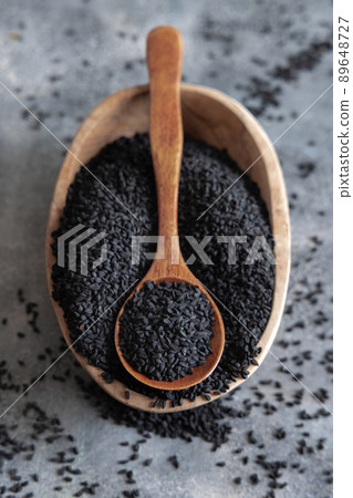 Indian spice Black cumin (nigella sativa or kalonji) seeds in bowl with spoon on wooden table top view. Indian spice Black cumin (nigella sativa or kalonji) seeds in bowl with spoon on wooden table top view. 89648727