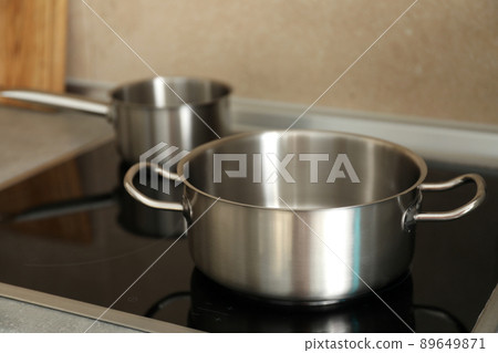 Metal pots on electric kitchen stove, selective focus Metal pots on electric kitchen stove, selective focus 89649871