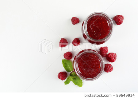 Jars of raspberry jam with ingredients on  white background 89649934