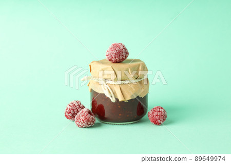 Jar of raspberry jam with ingredients on mint background Jar of raspberry jam with ingredients on mint background 89649974
