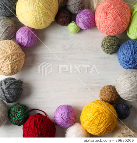 Multi colored balls of yarn on white wooden background Multi colored balls of yarn on white wooden background 89650209