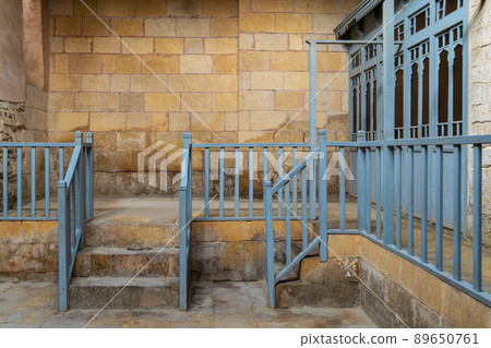 Abandoned historic traditional bathhouse with staircase leading to bricks stone wall, wooden blue balustrade, and doors of changing rooms, Medieval Cairo, Egypt Abandoned historic traditional bathhouse with staircase leading to bricks stone wall, wooden blue balustrade, and doors of changing rooms, Medieval Cairo, Egypt 89650761