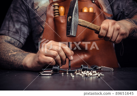 Leather Skinner working on a new leather product in workshop Leather Skinner working on a new leather product in workshop 89651645