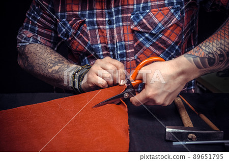 Artist working with leather creates quality product of leather in his work area 89651795