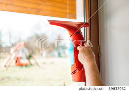 Cleaning windows with portable professional vacuum cleaner. 89652082
