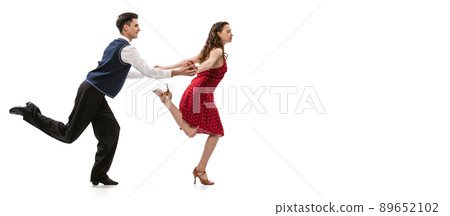 Quickstep. Beautiful girl and stylish man in vintage retro style outfits dancing isolated on white background. Timeless traditions, 60s,70s american fashion style and art Quickstep. Beautiful girl and stylish man in vintage retro style outfits dancing isolated on white background. Timeless traditions, 60s,70s american fashion style and art 89652102