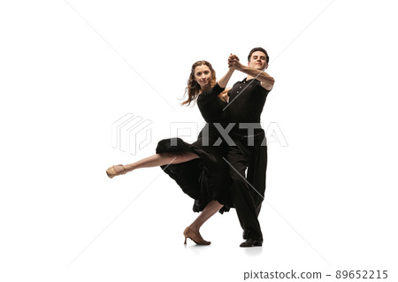 Portrait of young graceful dancers wearing black stage outfits dancing ballroom dance isolated on white background. Concept of art, beauty, music, style. Portrait of young graceful dancers wearing black stage outfits dancing ballroom dance isolated on white background. Concept of art, beauty, music, style. 89652215