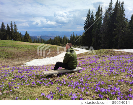 Man on wooden bench enjoying mountains landscape 89654014
