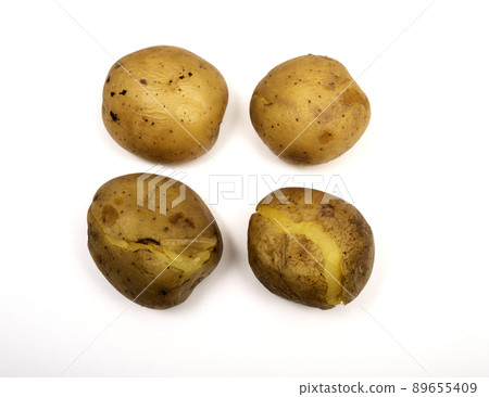 four boiled potatoes in their skins on a white 89655409