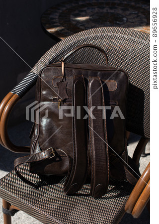 Brown leather backpack on the stylish chair Brown leather backpack on the stylish chair 89656928