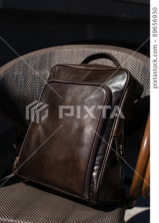Brown leather backpack on the stylish chair Brown leather backpack on the stylish chair 89656930