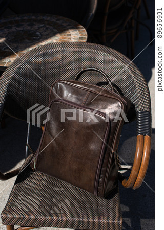 Brown leather backpack on the stylish chair Brown leather backpack on the stylish chair 89656931