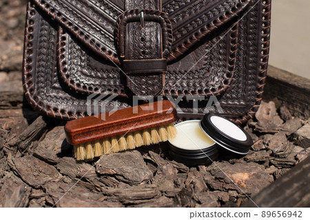 Wax and brush, leather maintenance concept. old genuine leather bag on a background. 89656942
