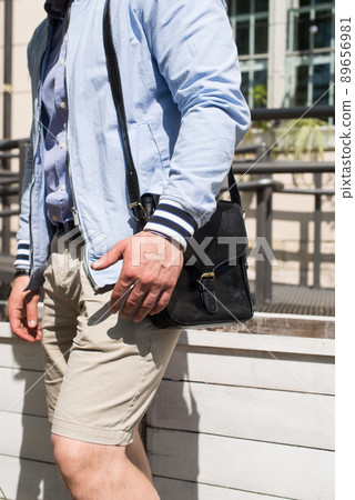 close-up photo of black leather bag in mans hand close-up photo of black leather bag in mans hand 89656981