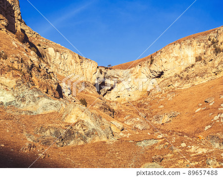 Autumn rocky plateau illuminated by the sun against the blue sky. Country mountain beauty of the Caucasus. Valley of the Narzans Autumn rocky plateau illuminated by the sun against the blue sky. Country mountain beauty of the Caucasus. Valley of the Narzans 89657488