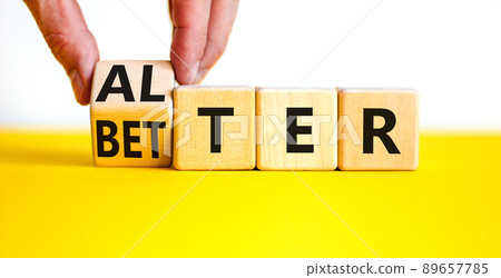 Alter or better symbol. Businessman turns wooden cubes and changes the word Alter to Better. Beautiful yellow table, white background, copy space. Business and alter or better concept. Alter or better symbol. Businessman turns wooden cubes and changes the word Alter to Better. Beautiful yellow table, white background, copy space. Business and alter or better concept. 89657785
