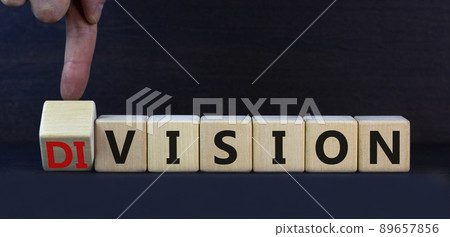Division or vision symbol. Turned cubes and changed the concept word Division to Vision. Businessman hand. Beautiful grey table grey background. Business division or vision concept. Copy space. 89657856