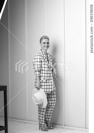 Elegant ant charismatic blond and short haired women with beautiful wide smile wearing oversized linen suit posing isolated in studio. Black and white version Elegant ant charismatic blond and short haired women with beautiful wide smile wearing oversized linen suit posing isolated in studio. Black and white version 89659606