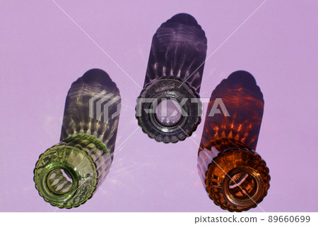 Glassware vases reflect sunlight shadow effect on a purple background. Play of shadows and sunlight. Glassware vases reflect sunlight shadow effect on a purple background. Play of shadows and sunlight. 89660699