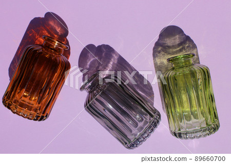Glassware vases reflect sunlight shadow effect on a purple background. Play of shadows and sunlight. Glassware vases reflect sunlight shadow effect on a purple background. Play of shadows and sunlight. 89660700