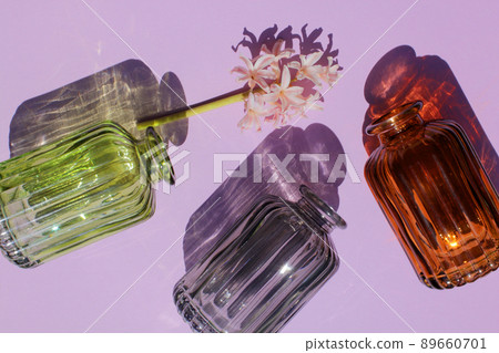 Glassware vases reflect sunlight shadow effect on a purple background. Play of shadows and sunlight. Glassware vases reflect sunlight shadow effect on a purple background. Play of shadows and sunlight. 89660701