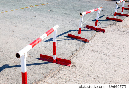 Metal road barrier with red and white striped caution pattern Metal road barrier with red and white striped caution pattern 89660775