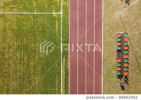 Top view of red running tracks and green grass lawn. Infrastructure for sports activities. 89662002
