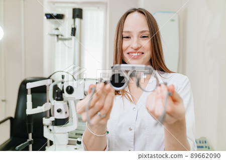 ophthalmologist with trial frame for selection of glasses. selective focus 89662090