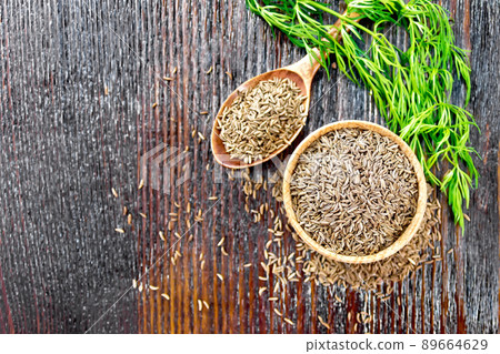 Cumin seeds in bowl and spoon with herbs on board top Cumin seeds in bowl and spoon with herbs on board top 89664629