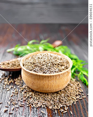 Cumin seeds in bowl and spoon with herbs on table Cumin seeds in bowl and spoon with herbs on table 89664631