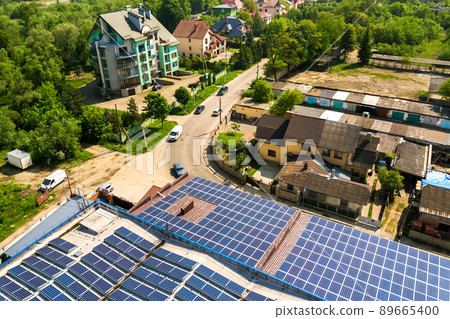 Aerial view of many photo voltaic solar panels mounted of industrial building roof. 89665400