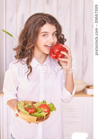 Young girl cooking at kitchen with vegetables. pretty child portrait. Chef 89667889