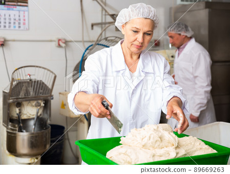 Woman weighing dough and preparing portioned pieces Woman weighing dough and preparing portioned pieces 89669263