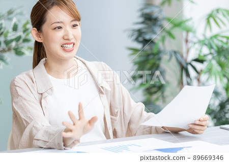 Young business woman speaking at a meeting Young business woman speaking at a meeting 89669346