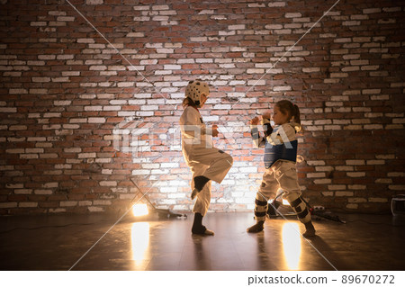 Karate training in the studio. Two little girls training karate skills. 89670272