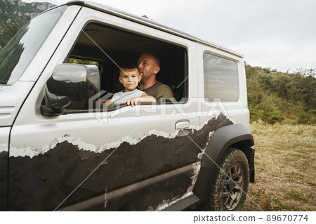 Father teaches little son to drive on road trip 89670774