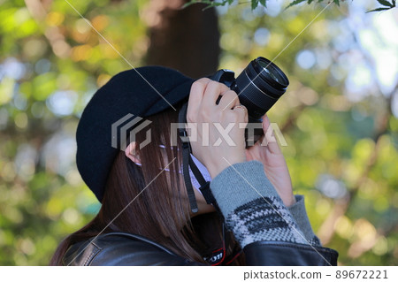 A woman holding a single-lens reflex camera A woman holding a single-lens reflex camera 89672221