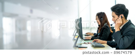 Business people wearing headset working in office in widen view Business people wearing headset working in office in widen view 89674579