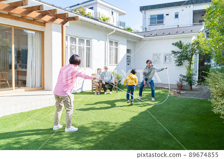 Three generation family playing in the garden 89674855