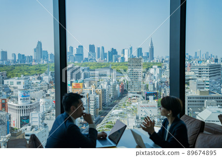 Cityscape with a businessman working in a fashionable building in Shibuya 89674895