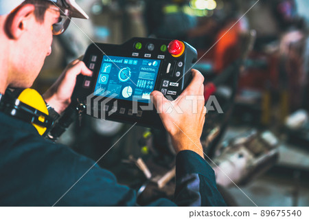 Young factory worker working with adept robotic arm 89675540