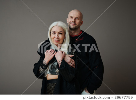 Horizontal medium close-up shot of handsome mature Caucasian man and attractive woman in love wearing stylish clothes looking at camera Horizontal medium close-up shot of handsome mature Caucasian man and attractive woman in love wearing stylish clothes looking at camera 89677799