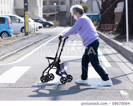 Elderly people taking a walk with a silver car 89678064